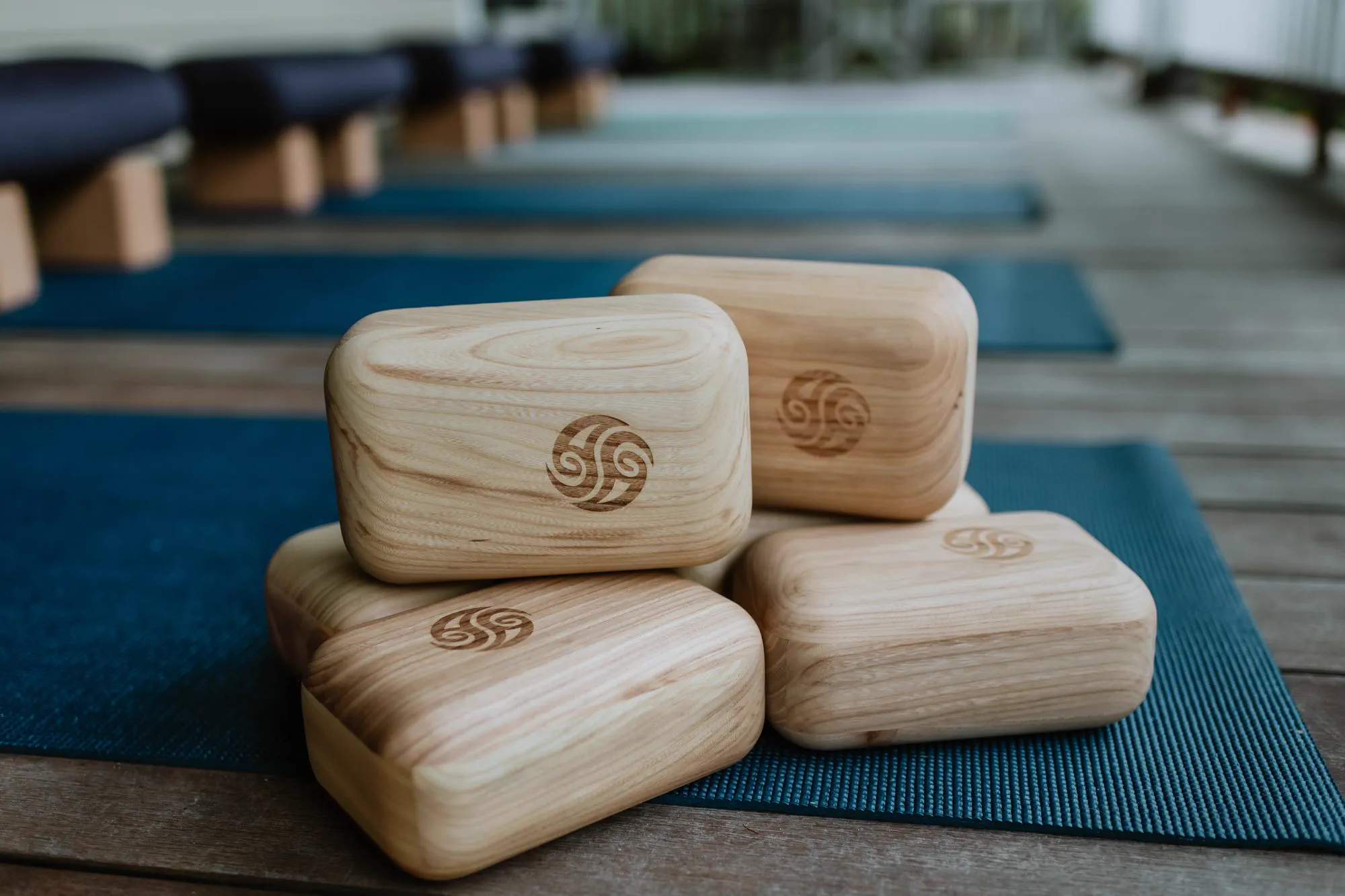 Carved bamboo Block Therapy tools resting on yoga mats.